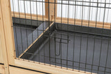 Holzgitterstruktur mit schwarzem Metallzaun und Verschlussmechanismus vor grauem Boden.