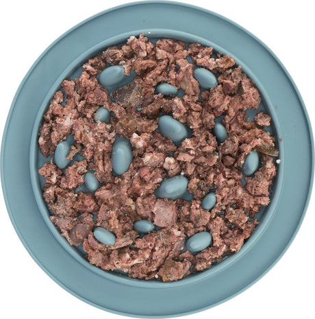 Gehacktes Futter mit brauner Farbe in einem blauen Napf, durchsetzt mit ovalen, blauen Erhebungen.