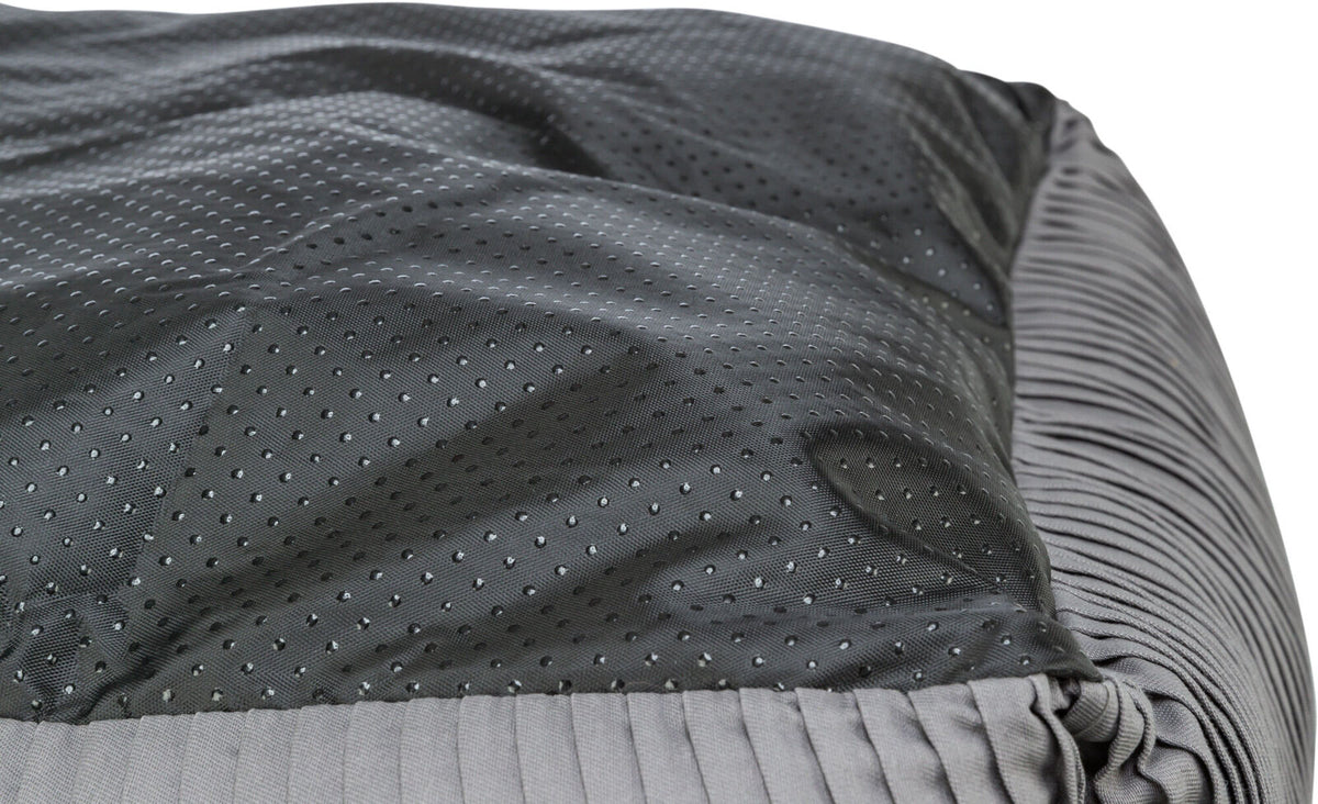 Graues und schwarzes, gepunktetes Textil mit geraffter Oberfläche, Nahaufnahme des Stoffes.
