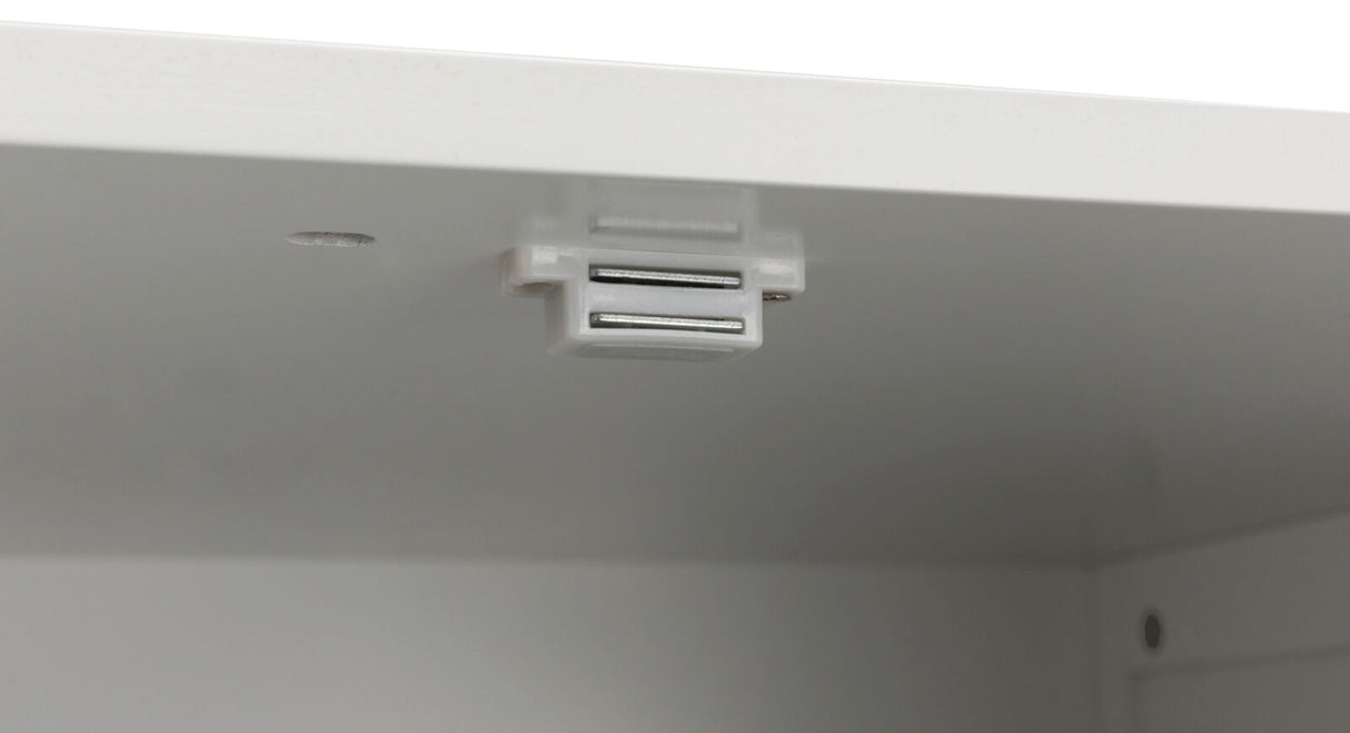 Weiße magnetische Schrankverriegelung an der Innenkante eines weißen Schrankes montiert.