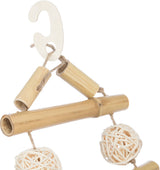 Dekoration aus Holz und Schnur mit hängenden Kugeln aus geflochtenem Material, beige und naturfarben.