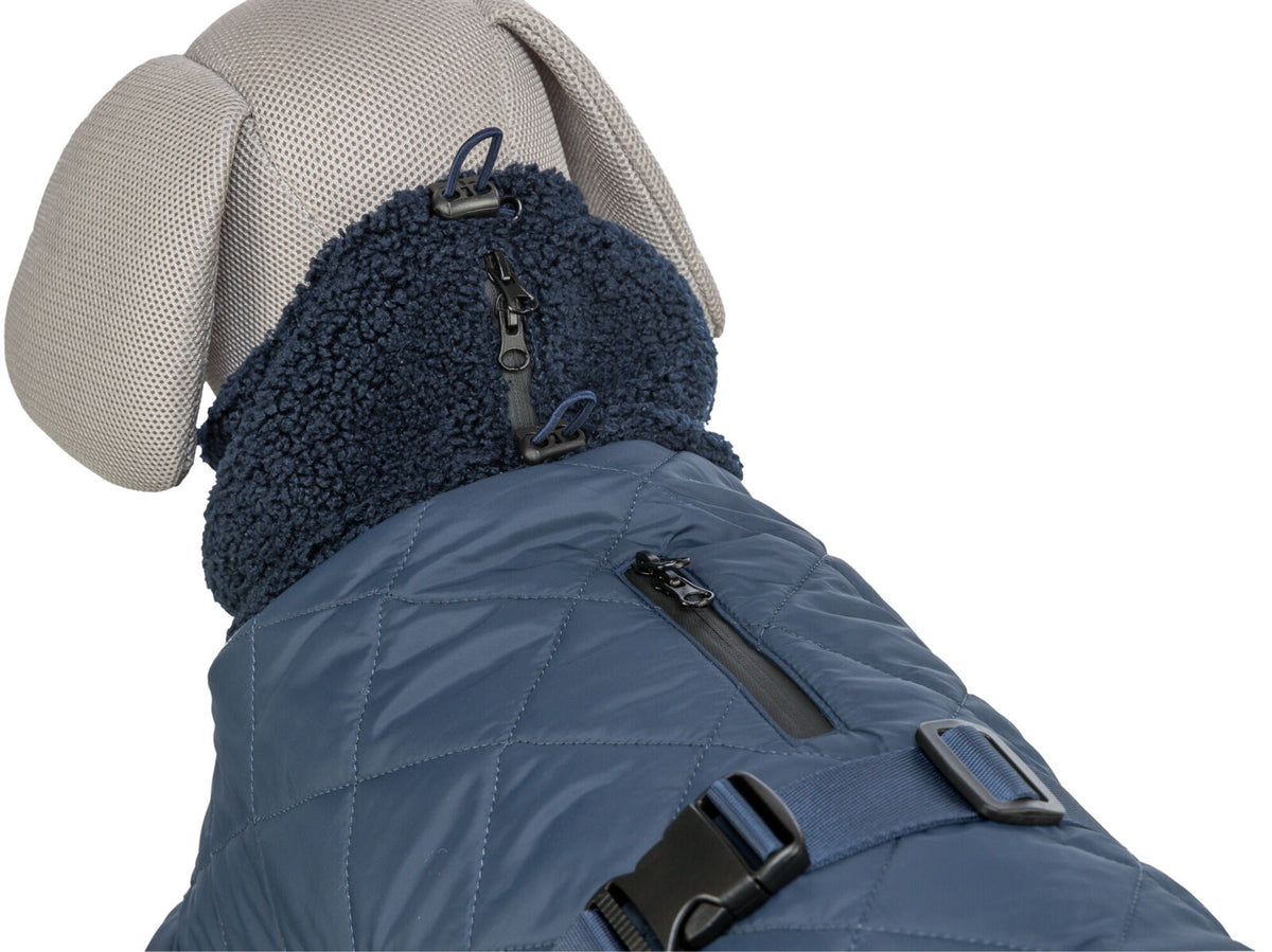 Hundemantel in Blau mit Steppmuster und Reißverschlüssen, getragen von einem hellen Hundemodell.