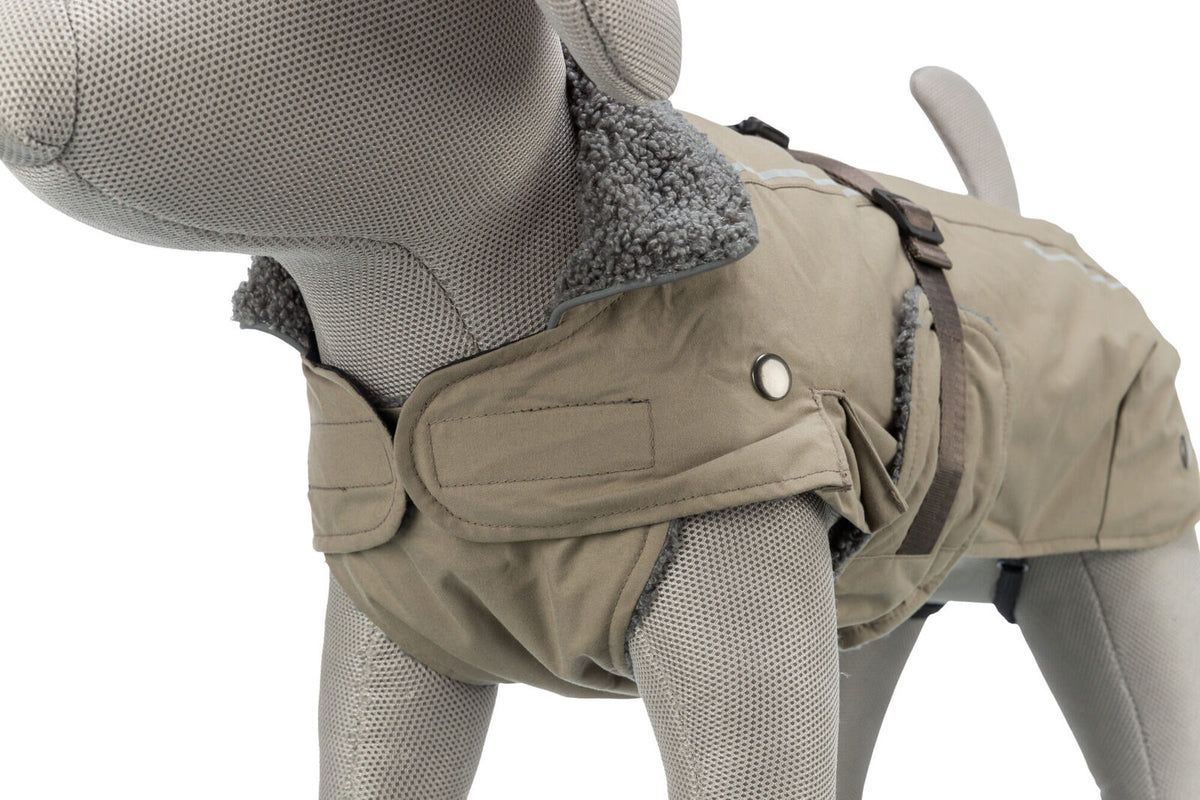 Grauer Hundemantel auf einem Stoffmodell mit flauschigem Kragen, Taschen und Schnallen in Beige und Braun.