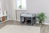 Grauer Hundekäfig im Wohnzimmer mit kleinem Hund darin, umgeben von Pflanzen und moderner Einrichtung.