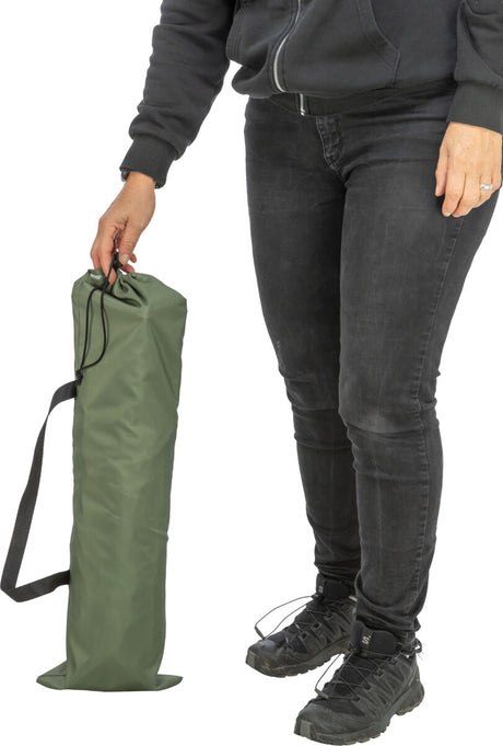 Person in schwarzer Kleidung hält eine grüne Tasche mit schwarzem Riemen in der Hand.