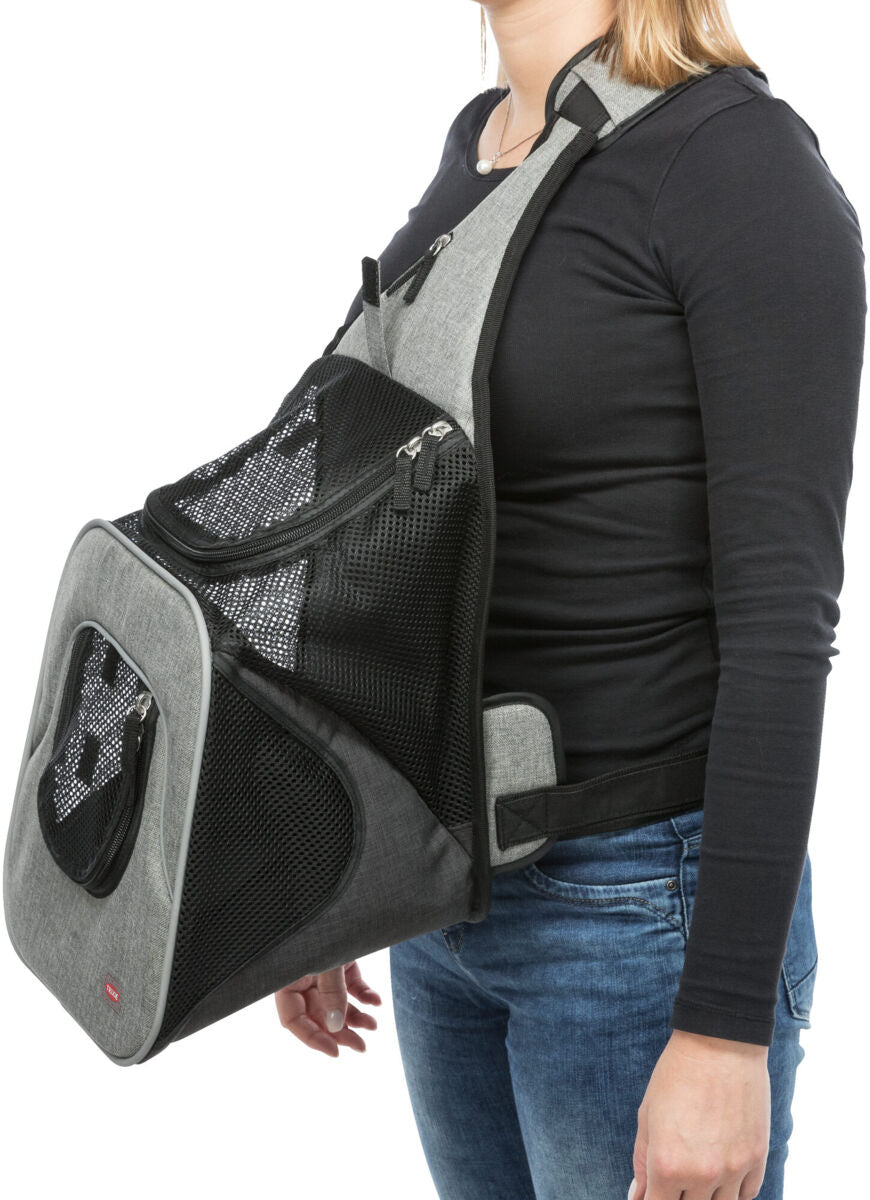 Eine Person trägt eine schwarze Tragetasche mit Netzstoff und Reißverschlüssen über der Schulter.