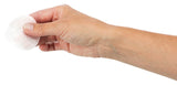 Eine Hand hält ein rundes weißes, perforiertes Pad oder Tuch vor weißem Hintergrund, das zwischen Daumen und Zeigefinger fixiert ist.